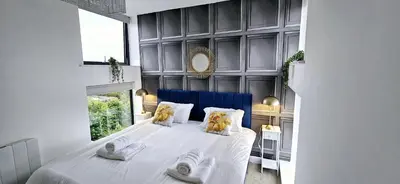 a bedroom with a large white bed with two pillows at Stylish 2 Bedroom Flat near Chelmsford Station, with Free Parking, Sleeps 4 in Chelmsford