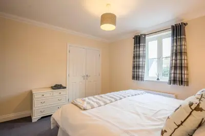 a bedroom with a white bed and a window at Comfortable 2-Bedroom Home in Framlingham in Framlingham