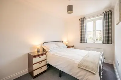 a bedroom with a bed and a window at Comfortable 2-Bedroom Home in Framlingham in Framlingham