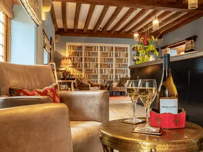 a room with a table with two glasses of wine at The Old Hall Ely in Ely