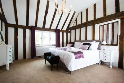 a bedroom with a large bed and a chandelier at The Harvard Inn in Stock