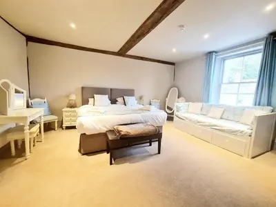 a large bedroom with a bed and a couch at The Harvard Inn in Stock