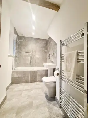 a bathroom with a toilet and a sink and a tub at The Harvard Inn in Stock