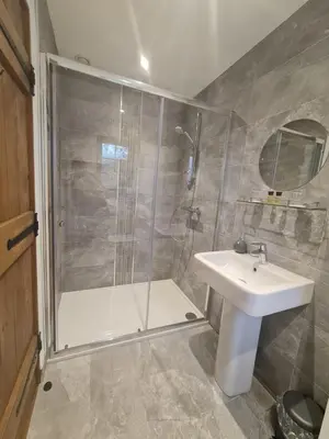 a bathroom with a shower and a sink at The Harvard Inn in Stock