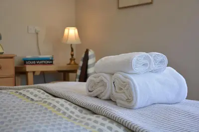 a pile of towels sitting on top of a bed at The Dolphin Inn in Thorpeness