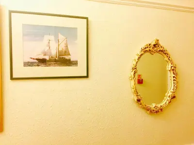 a mirror on a wall with a picture of a ship at Southend Inn Hotel - Close to Beach, Train Station & Southend Airport in Southend-on-Sea