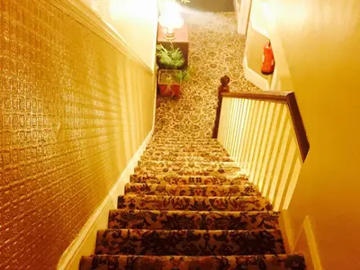 a staircase in a building with a stair case at Southend Inn Hotel - Close to Beach, Train Station & Southend Airport in Southend-on-Sea