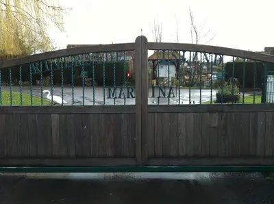 a wooden gate with a park in the background at Isleham River Lodge in Isleham