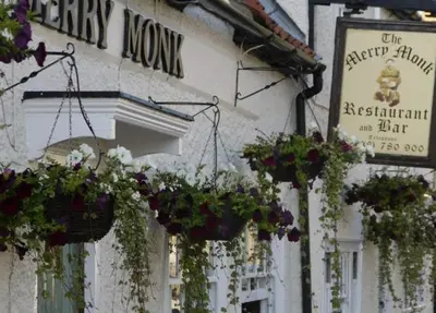 a building with potted plants on the side of it at Isleham River Lodge in Isleham