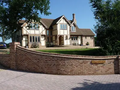 a brick fence in front of a house at Oakwrights in Terling