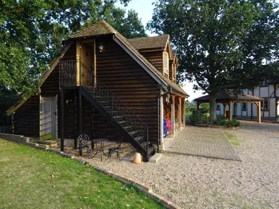 a small wooden building with a staircase on it at Oakwrights in Terling