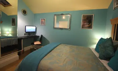 a bedroom with a bed and a television in it at The PitStop in Bishops Stortford