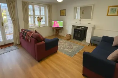 a living room with two couches and a fireplace at Little Chequers in Friston