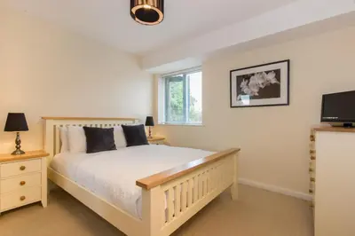 a bedroom with a bed and a flat screen tv at Citystay Living - Dove House in Cambridge