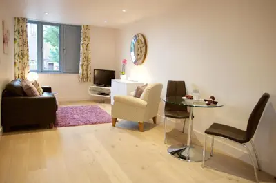 a living room with a couch and a table and chairs at Citystay Living - Pringle House in Cambridge