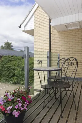 a patio table and chairs on a deck with flowers at Citystay Living - Citygate in Cambridge