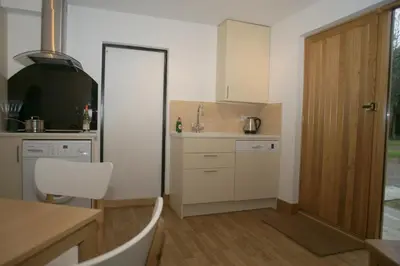 a kitchen with a sink and a table and a door at The Elms Annex in Cottered