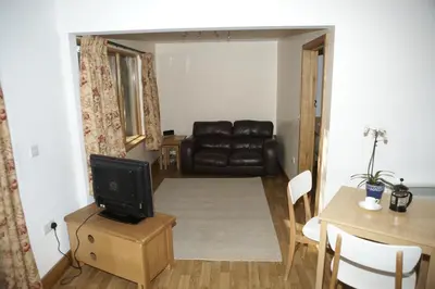 a living room with a couch and a television at The Elms Annex in Cottered