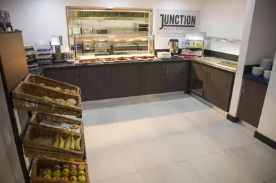 a kitchen with a counter with a bunch of food at Ramada Cambridge in Cambridge