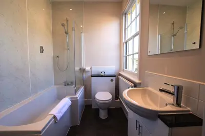 a bathroom with a sink and a toilet and a shower at The Crown Inn Hotel in Long Melford