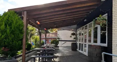an outdoor patio with a wooden pergola at The Park Hotel - Sure Hotel Collection by Best Western in Diss