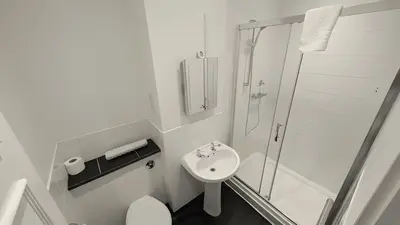 a white bathroom with a shower and a sink at The Park Hotel - Sure Hotel Collection by Best Western in Diss