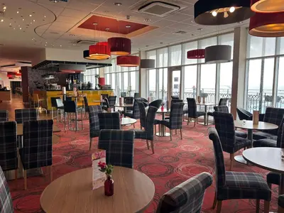 a dining room with tables and chairs and windows at The Palace Hotel in Southend-on-Sea