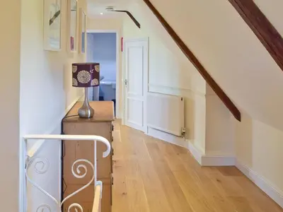 a staircase in a house with a stair case at Granary Cottage in Bentley