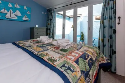 a bedroom with a bed with a comforter on it at Waterfront Cottage in Aldeburgh
