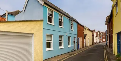 a row of colourful houses on a street at Waterfront Cottage in Aldeburgh