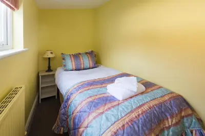 a bedroom with a bed with two towels on it at Waterfront Cottage in Aldeburgh