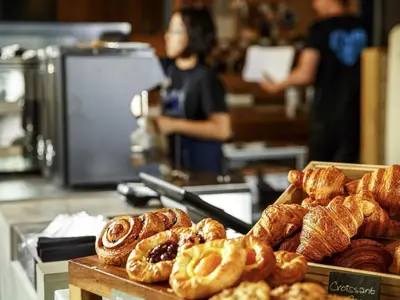 a bunch of pastries on a counter in a bakery at ibis Cambridge Central Station in Cambridge