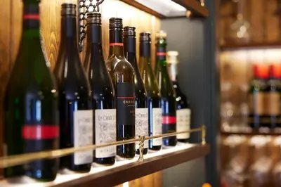 a bunch of wine bottles sitting on a shelf at The Bushel by Greene King Inns in Bury Saint Edmunds