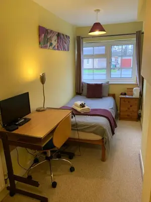 a bedroom with a bed and a desk with a computer at The Holly Tree in Cambridge