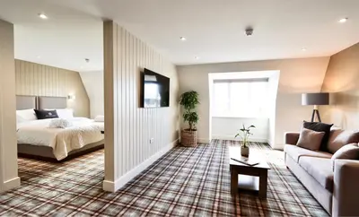 a bedroom with a bed and a couch at All Saints Resort in Bury Saint Edmunds