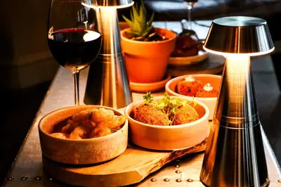 a table with bowls of food and a glass of wine at All Saints Resort in Bury Saint Edmunds