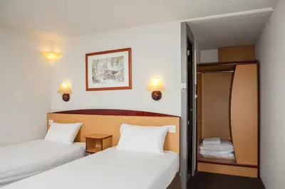 a hotel room with two beds and a mirror at Campanile Hotel - Basildon - East of London in Basildon