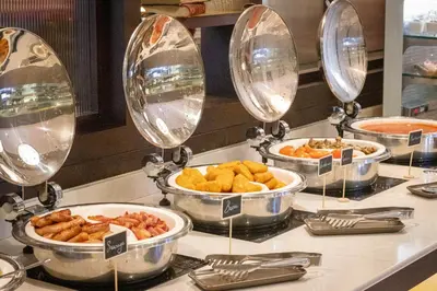 a buffet with several bowls of food on a counter at Clayton Hotel Cambridge in Cambridge