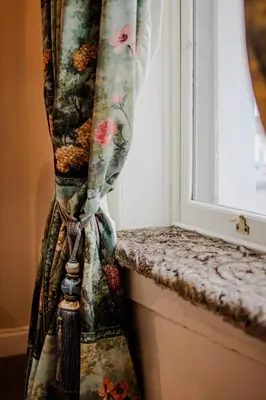 a curtain next to a window in a room at The White Hart Hotel in Hingham