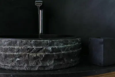 a bathroom with a stone tub with a water fountain at The White Hart Hotel in Hingham