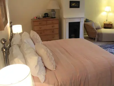 a bedroom with a bed with pillows and a fireplace at Church Farmhouse B & B in Kennett