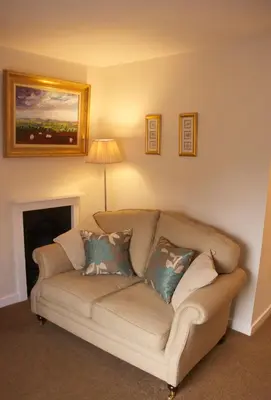 a living room with a couch and a fireplace at Chantry Hotel in Bury Saint Edmunds