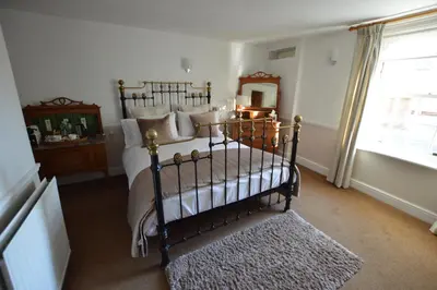 a bedroom with a bed and a mirror and a window at Chantry Hotel in Bury Saint Edmunds
