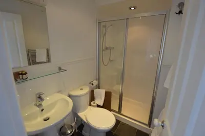a bathroom with a shower and a toilet and a sink at Chantry Hotel in Bury Saint Edmunds