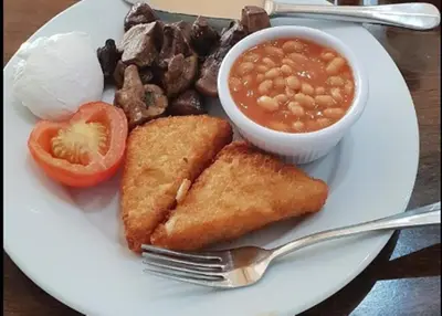 a plate of food with beans beans and a bowl of soup at Esplanade Hotel - Clacton On Sea, Beachfront Hotel by OYO in Clacton-on-Sea