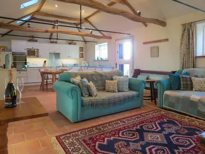 a living room with two couches and a kitchen at Appletree Cottage Fressingfield in Fressingfield