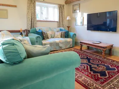 a living room with a couch and a tv at Appletree Cottage Fressingfield in Fressingfield