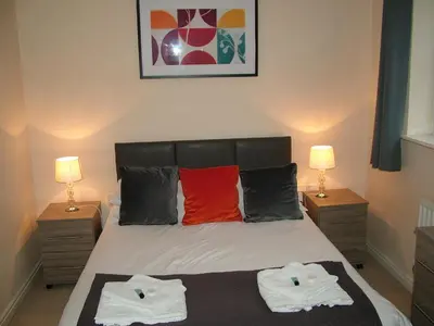 a bedroom with a bed with two towels on it at Thistle Cottage in Mildenhall