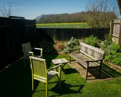 three chairs and a bench in a garden at Fox Inn in Darsham