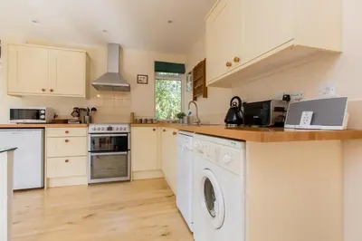 a kitchen with a washer and dryer at The Retreat, Unique property located in calming woodland surroundings, Close to Aldeburgh and Thorpeness in Leiston